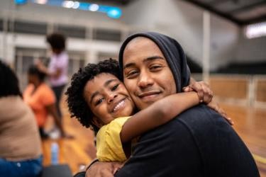 retrato de padre e hija abrazándose en un centro comunitario - inmigrantes en usa fotografías e imágenes de stock