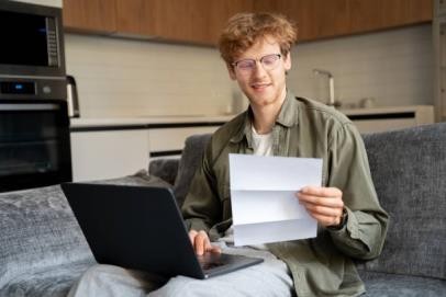 ginger irlandés freelance que trabaja con computadora portátil y documentos en la oficina en casa - préstamos estudiantiles fotografías e imágenes de stock